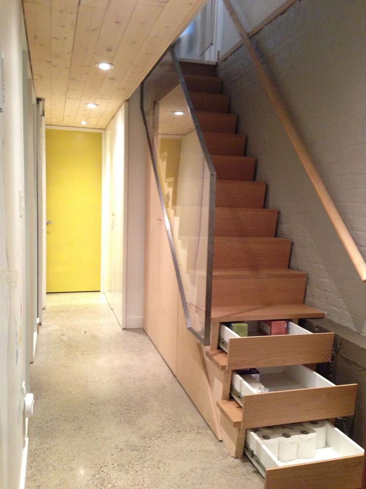 Photo of a small modern wood straight glass railing staircase in Toronto with wood risers.