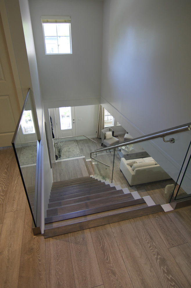 На фото: лестница в стиле модернизм с стеклянными перилами с