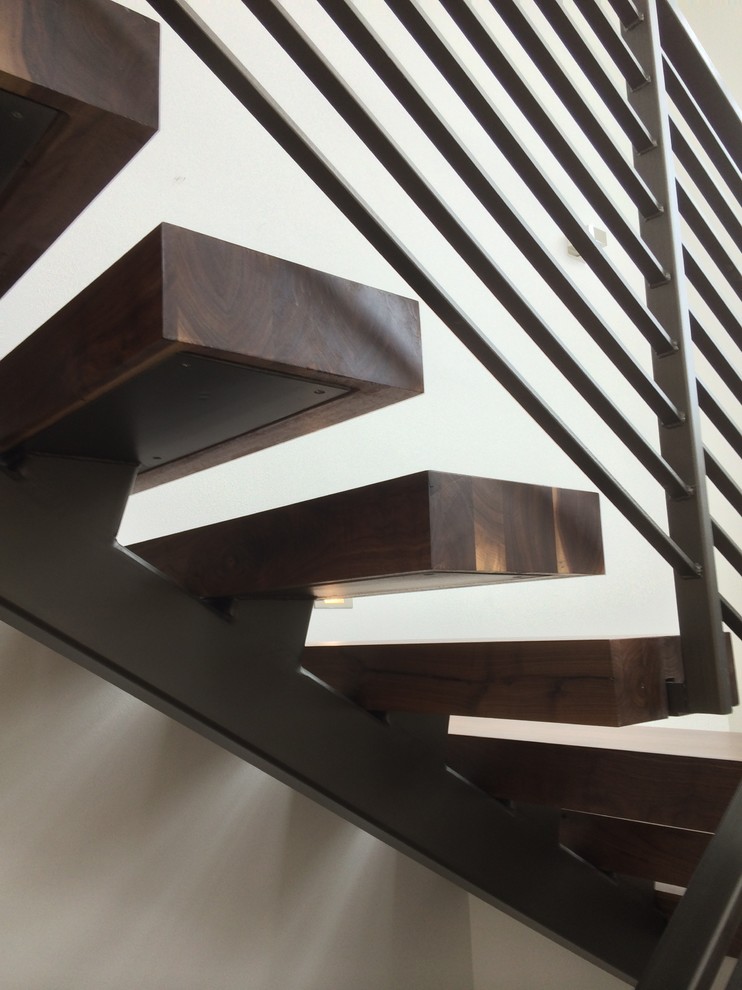 Ejemplo de escalera suspendida industrial de tamaño medio con escalones de madera y contrahuellas de madera