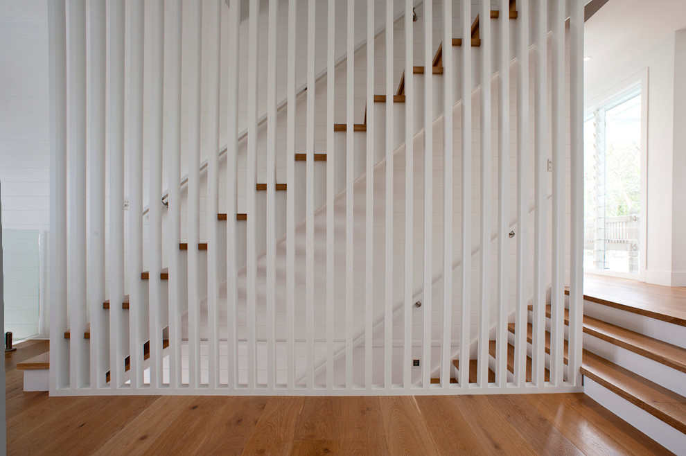 На фото: прямая лестница среднего размера в стиле модернизм с деревянными ступенями без подступенок