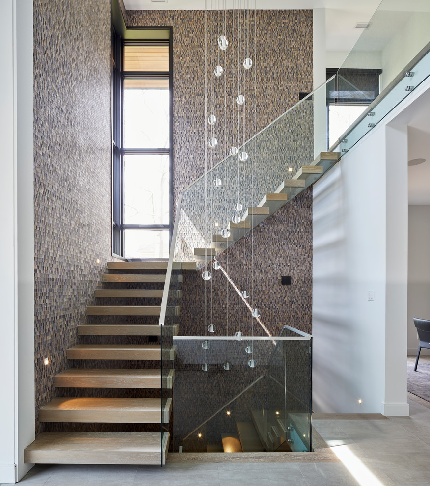 Diseño de escalera en L contemporánea sin contrahuella con escalones de madera y barandilla de vidrio
