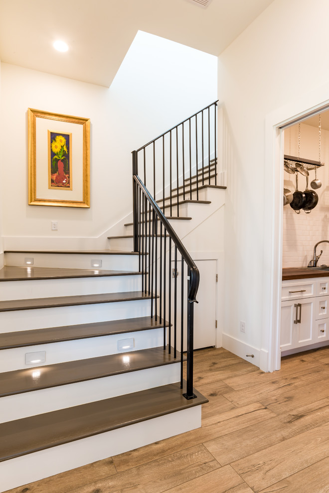 Staircase - large traditional wooden l-shaped metal railing staircase idea in Houston with wooden risers