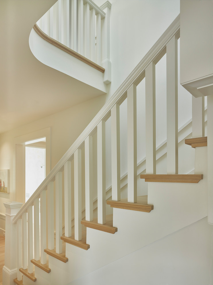 На фото: угловая лестница среднего размера в классическом стиле с деревянными ступенями, крашенными деревянными подступенками и деревянными перилами с