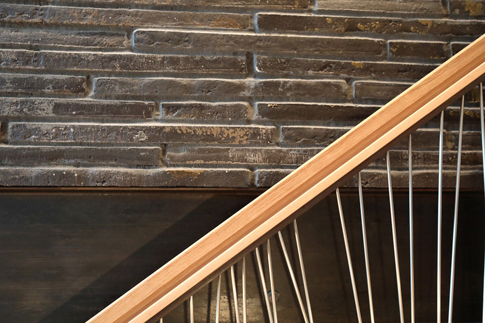 Cette image montre un grand escalier sans contremarche droit minimaliste avec des marches en bois et un garde-corps en matériaux mixtes.