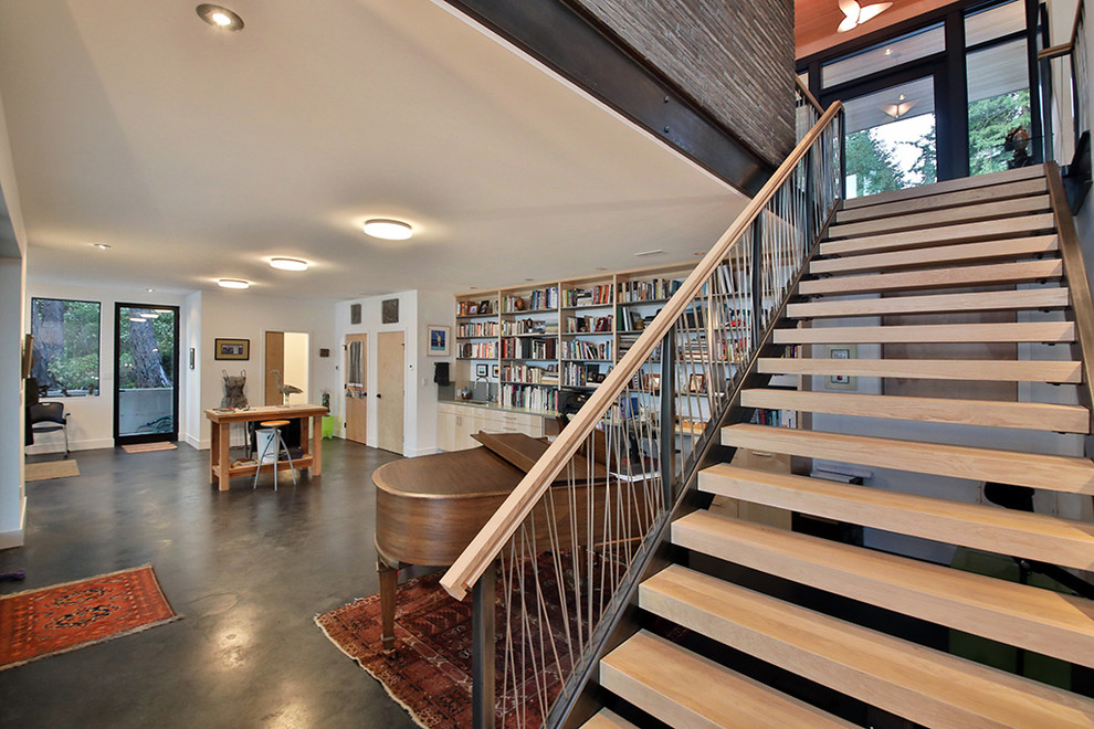 Photo of a large modern wood straight mixed railing staircase in Seattle with open risers.