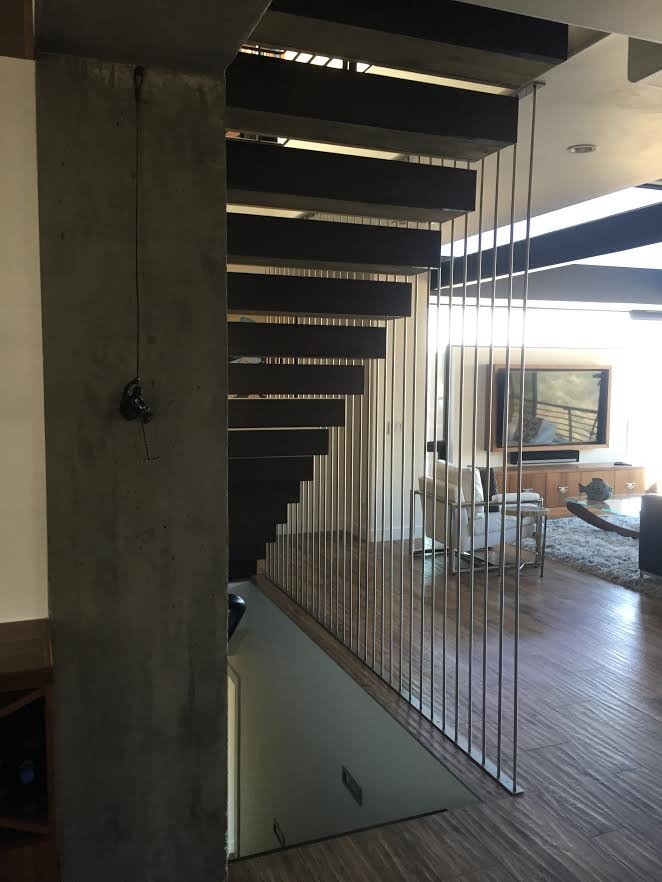 Diseño de escalera recta moderna grande sin contrahuella con escalones de madera