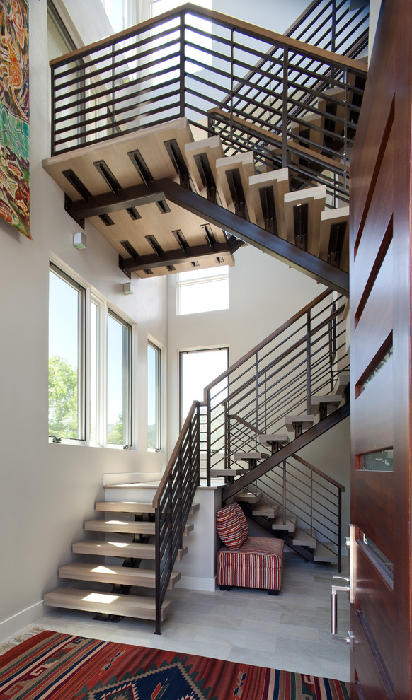 На фото: большая п-образная лестница в современном стиле с деревянными ступенями и перилами из смешанных материалов без подступенок