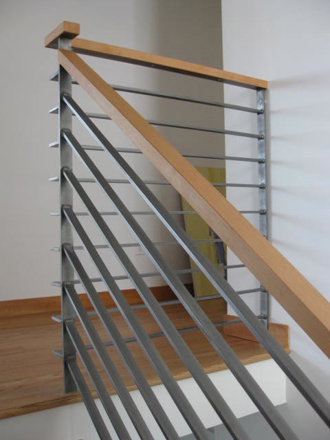 Modelo de escalera en L contemporánea de tamaño medio con escalones de madera, contrahuellas de madera y barandilla de metal