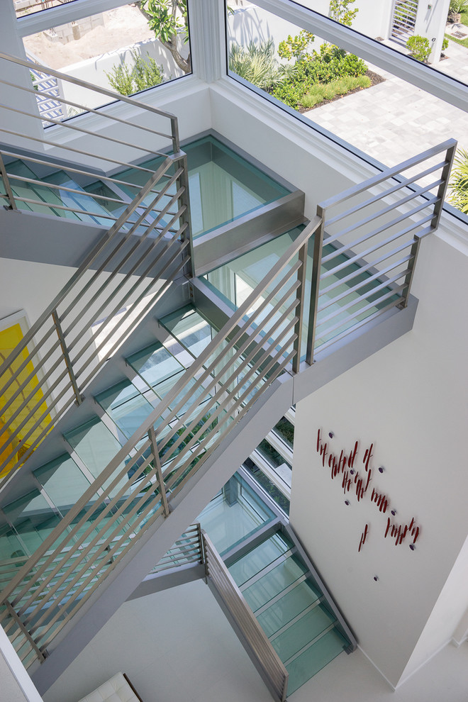 Idée de décoration pour un grand escalier sans contremarche minimaliste en U avec des marches en verre.