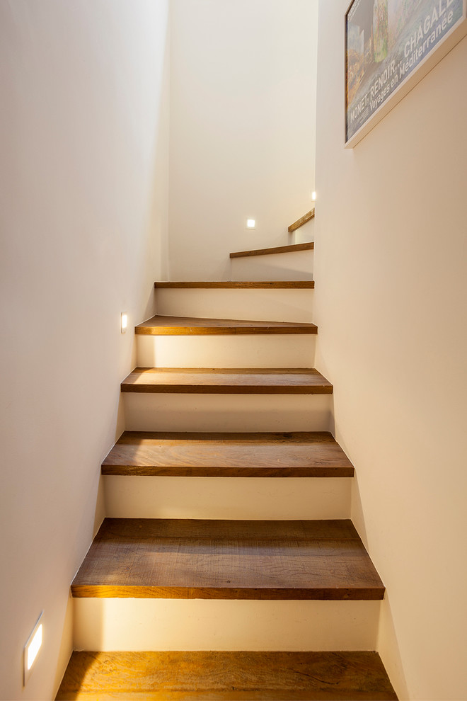 Идея дизайна: угловая бетонная лестница в стиле фьюжн с деревянными ступенями