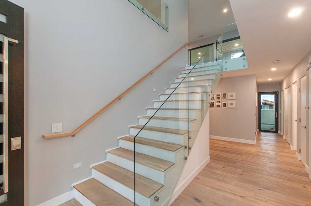 Example of a mid-sized minimalist wooden straight glass railing staircase design in San Diego with painted risers