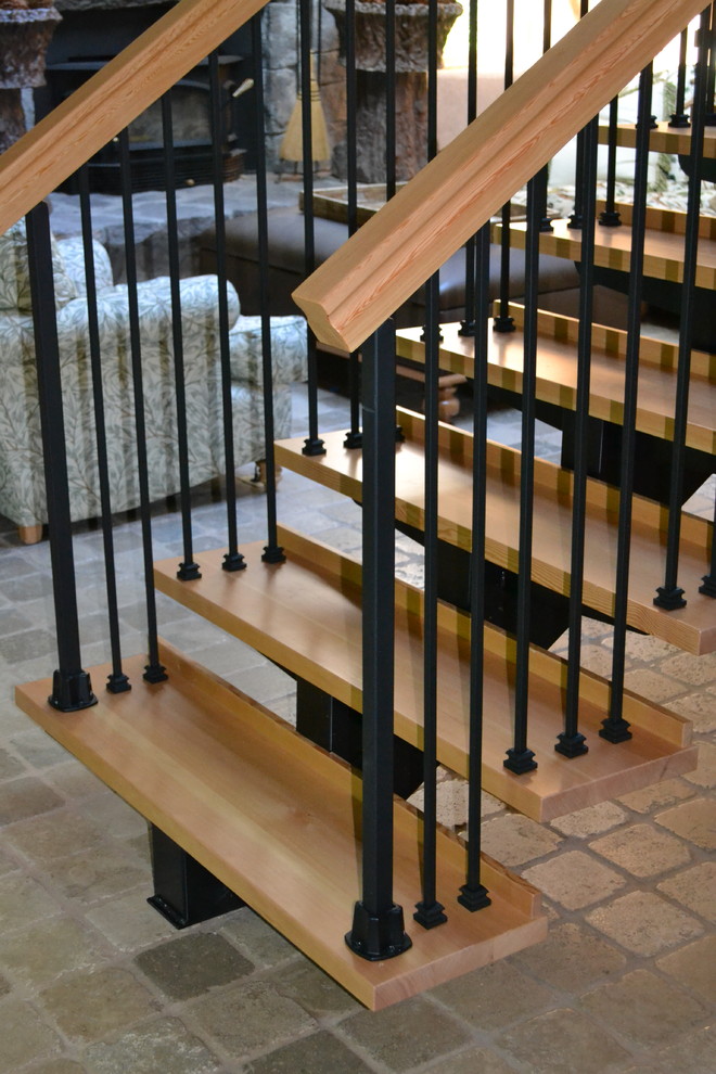 Photo of a large rustic wood l-shaped wood railing staircase in Portland with open risers.