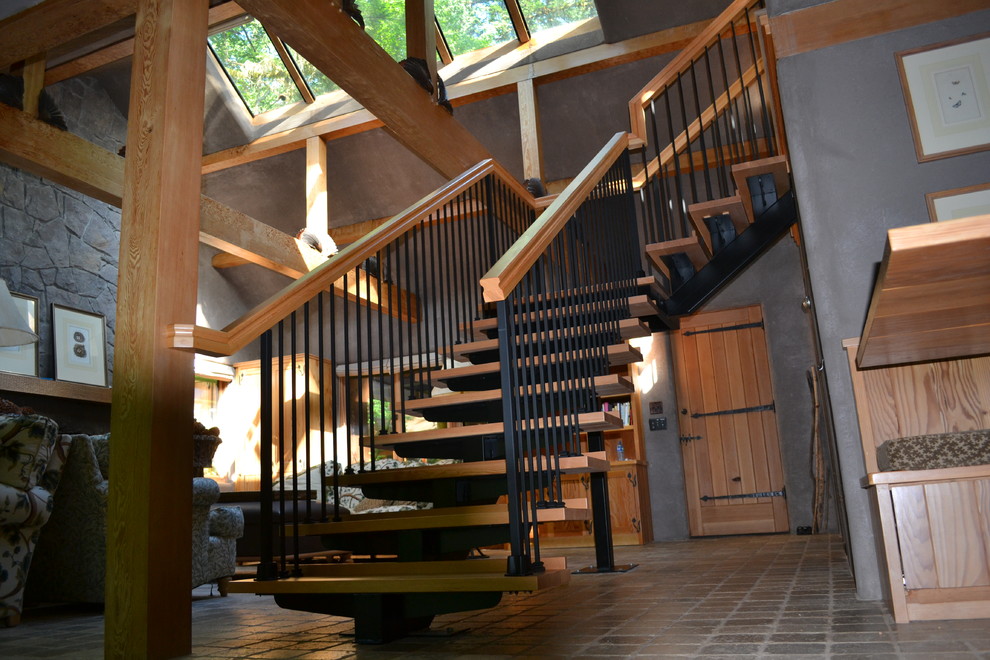 Ejemplo de escalera en L rural grande sin contrahuella con escalones de madera y barandilla de madera