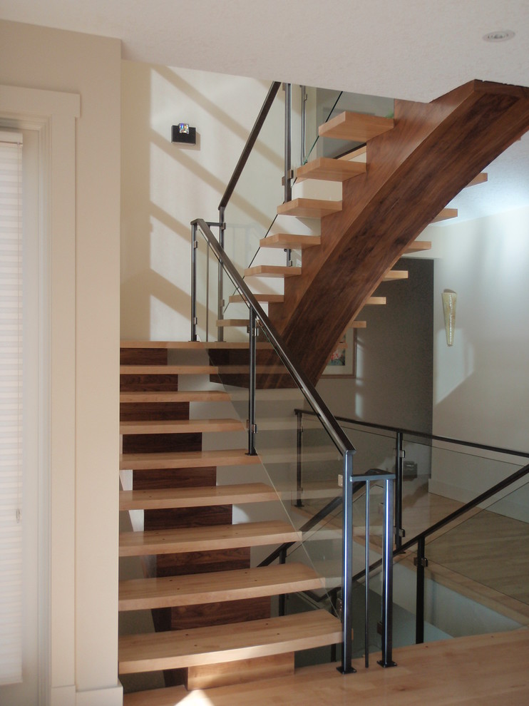 This is an example of a contemporary wood u-shaped glass railing staircase in Calgary with open risers.