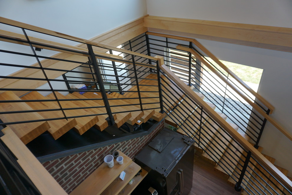 Photo of a medium sized urban metal l-shaped metal railing staircase in Columbus with wood risers.