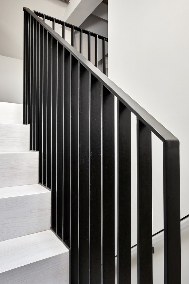 Inspiration pour un grand escalier courbe design avec un garde-corps en métal, des marches en bois et des contremarches en métal.