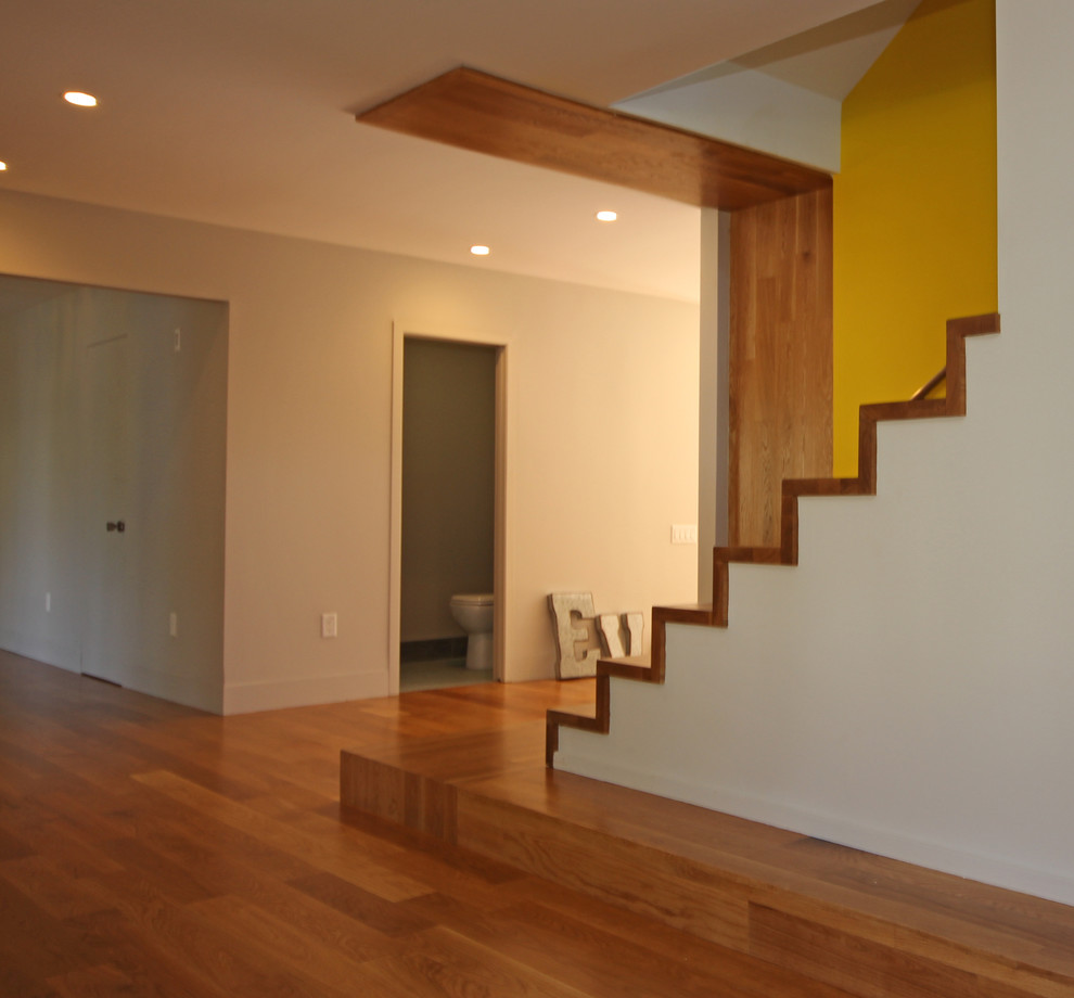 Photo of a large modern wood straight staircase in New York with wood risers.