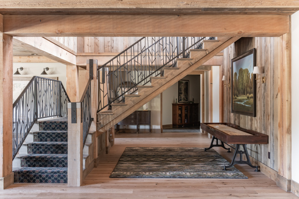 Große Urige Treppe in L-Form mit Teppich-Treppenstufen, Teppich-Setzstufen, Stahlgeländer und Holzwänden in Sonstige