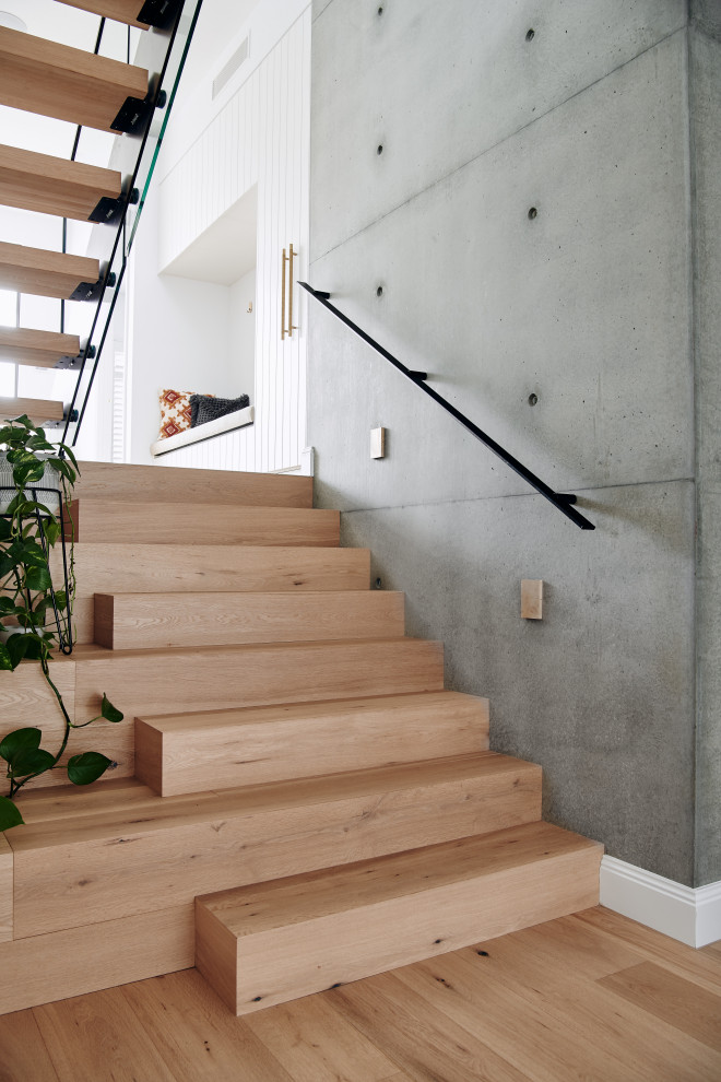 Идея дизайна: большая п-образная лестница в морском стиле с деревянными ступенями, металлическими перилами и панелями на стенах без подступенок