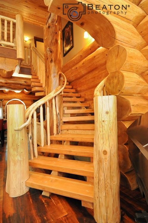 デンバーにある高級な中くらいなラスティックスタイルのおしゃれなサーキュラー階段 (木材の手すり) の写真