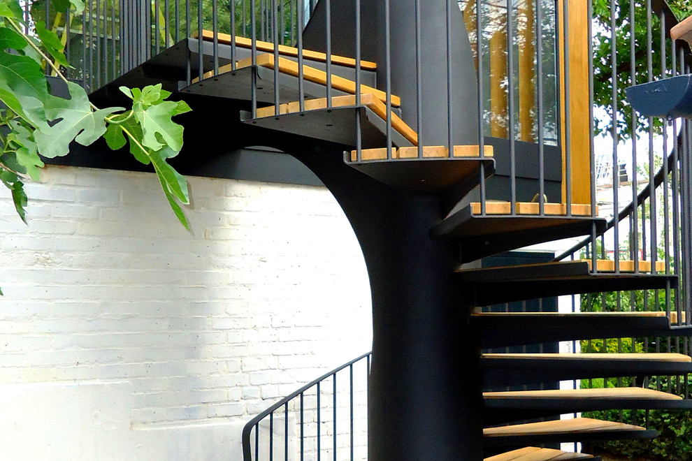 Inspiration for a contemporary wooden spiral staircase remodel in Other with metal risers
