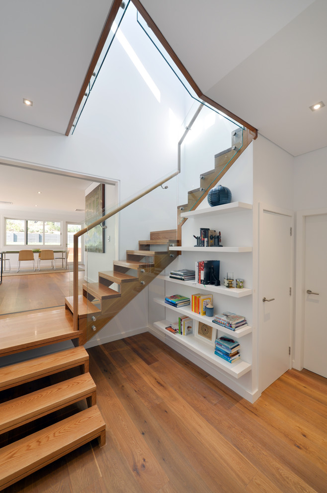 Источник вдохновения для домашнего уюта: большая изогнутая лестница в современном стиле с деревянными ступенями без подступенок