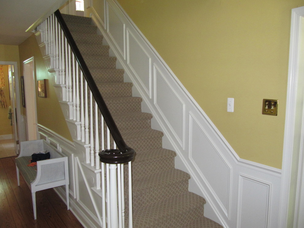 Diseño de escalera recta tradicional de tamaño medio con escalones enmoquetados, contrahuellas enmoquetadas y barandilla de madera