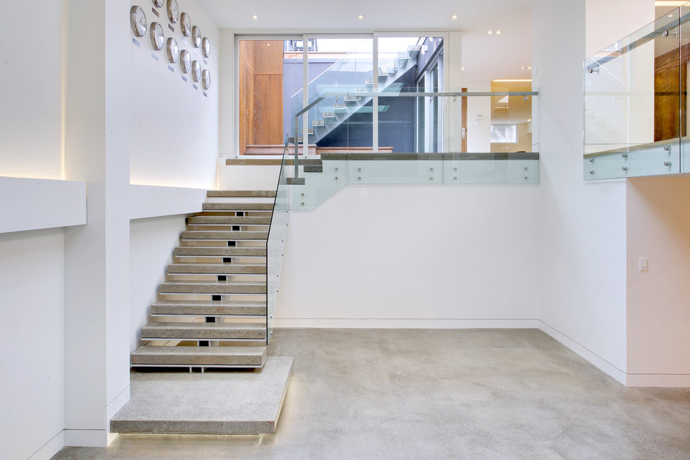 Design ideas for a large scandi concrete straight staircase in Toronto with open risers.