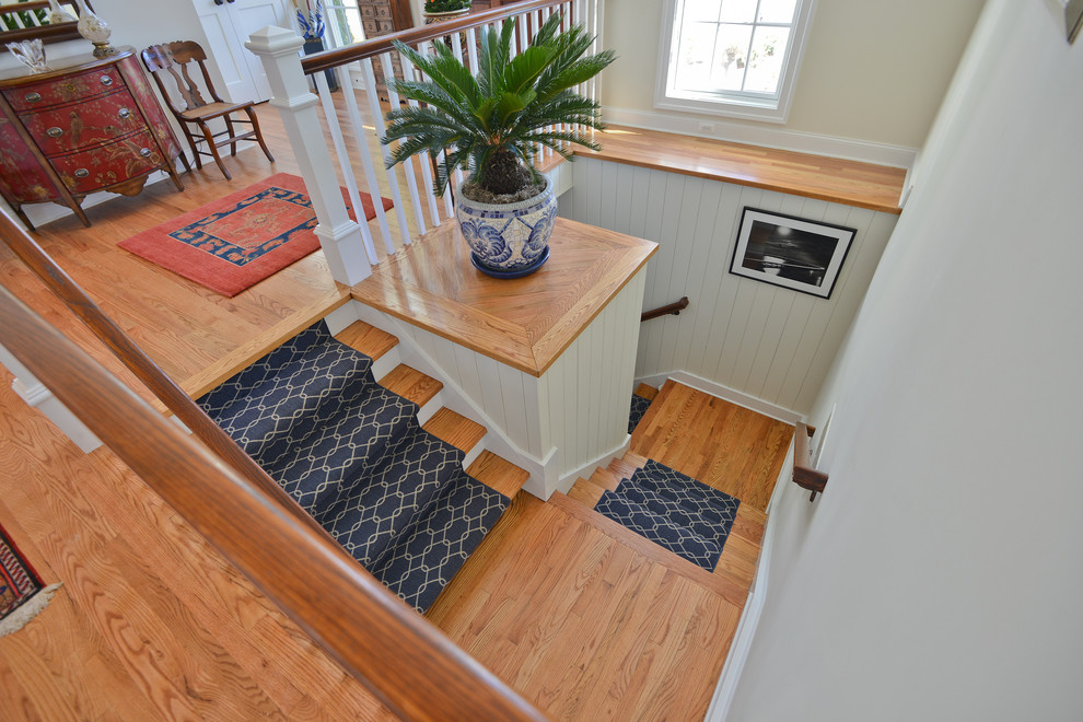 Ejemplo de escalera en U con escalones de madera y contrahuellas de madera pintada