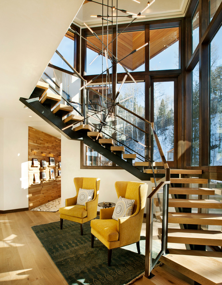 Ejemplo de escalera rural sin contrahuella con escalones de madera y barandilla de vidrio