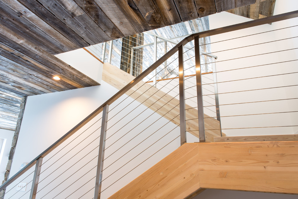 Ejemplo de escalera recta rústica de tamaño medio sin contrahuella con escalones de madera y barandilla de metal