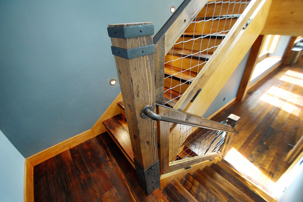 Idee per un'ampia scala a rampa dritta stile rurale con pedata in legno, alzata in legno e parapetto in materiali misti