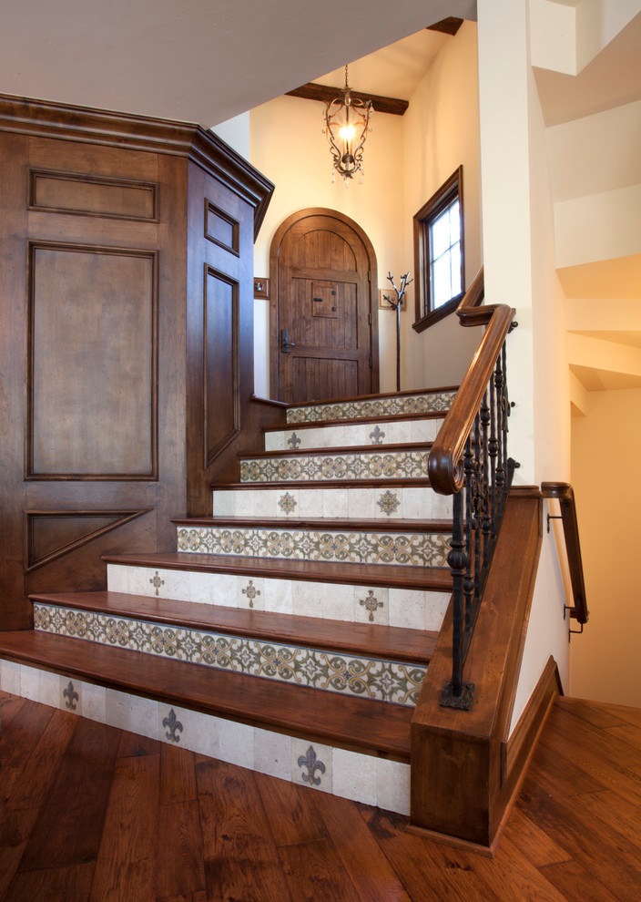 Cette image montre un très grand escalier courbe traditionnel avec des marches en bois et des contremarches carrelées.