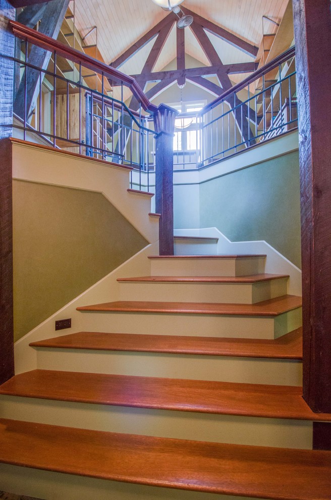Источник вдохновения для домашнего уюта: изогнутая лестница среднего размера в стиле кантри с деревянными ступенями и крашенными деревянными подступенками
