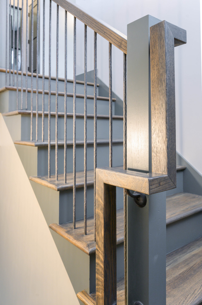 Aménagement d'un escalier peint droit classique avec des marches en bois et un garde-corps en métal.