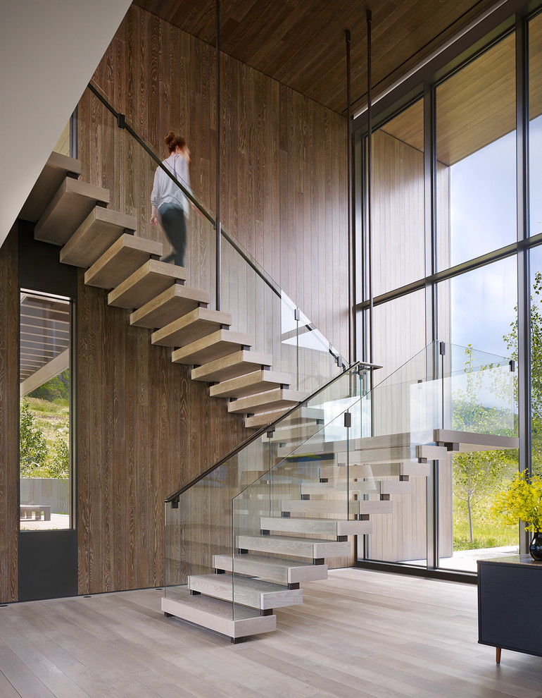 Exempel på en modern trappa i trä, med öppna sättsteg och räcke i metall