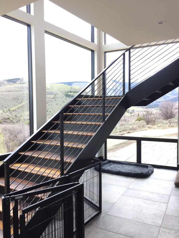 Diseño de escalera suspendida moderna extra grande con escalones de madera, contrahuellas de metal y barandilla de metal