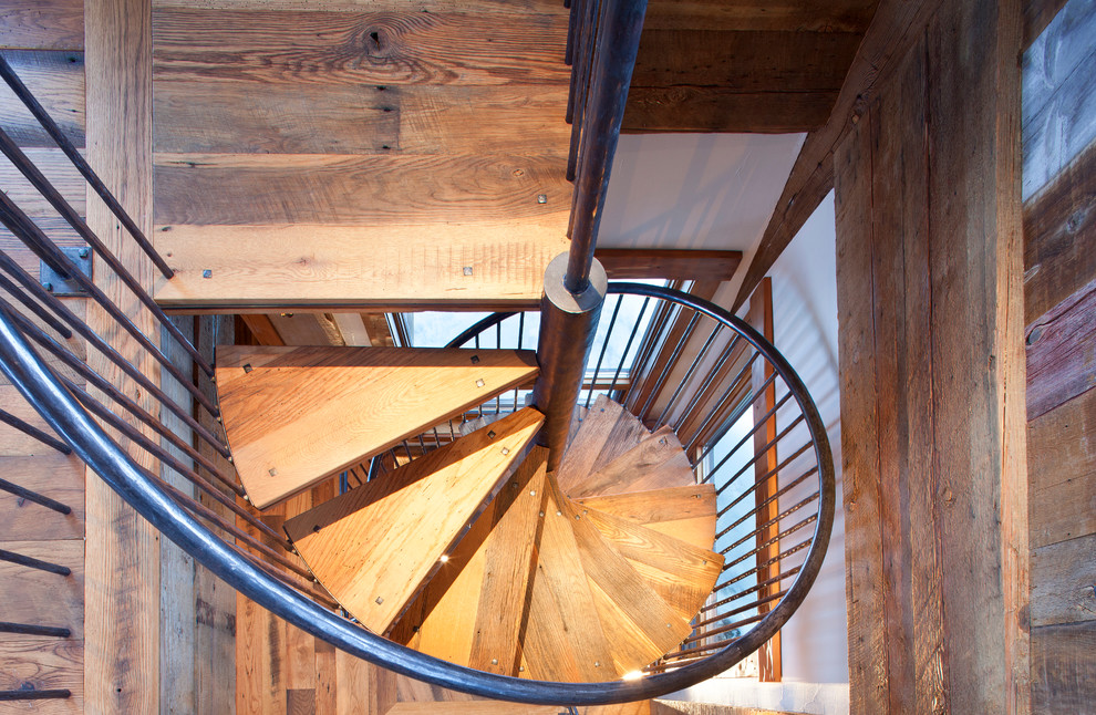 Пример оригинального дизайна: большая винтовая лестница в стиле рустика с деревянными ступенями без подступенок