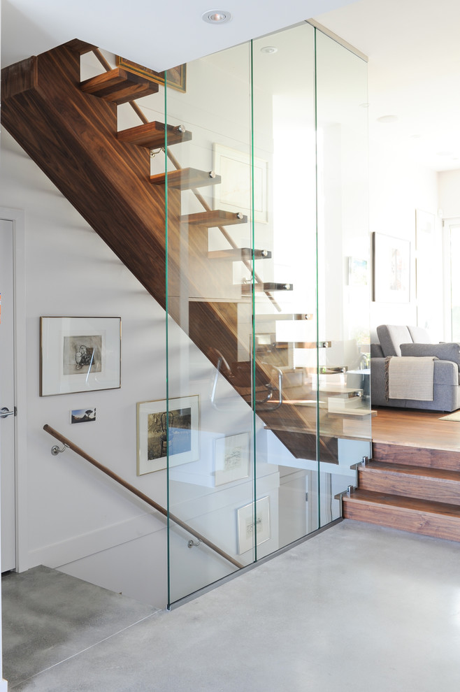 This is an example of a medium sized contemporary wood straight staircase in Vancouver with wood risers.