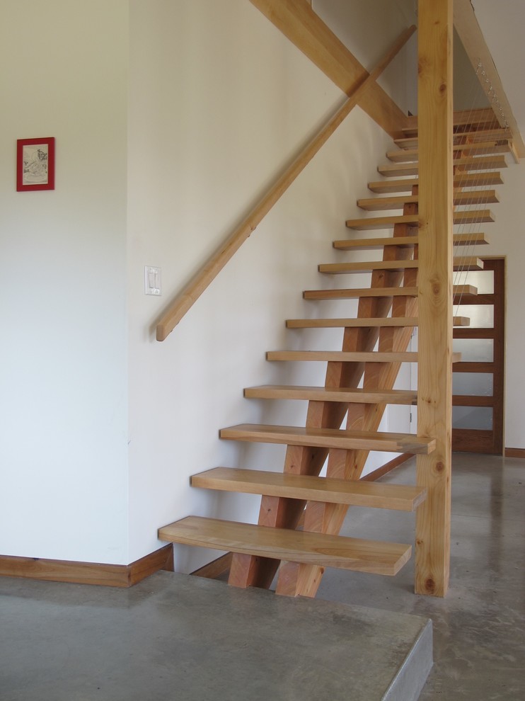 Foto de escalera suspendida moderna grande sin contrahuella con escalones de madera y barandilla de madera