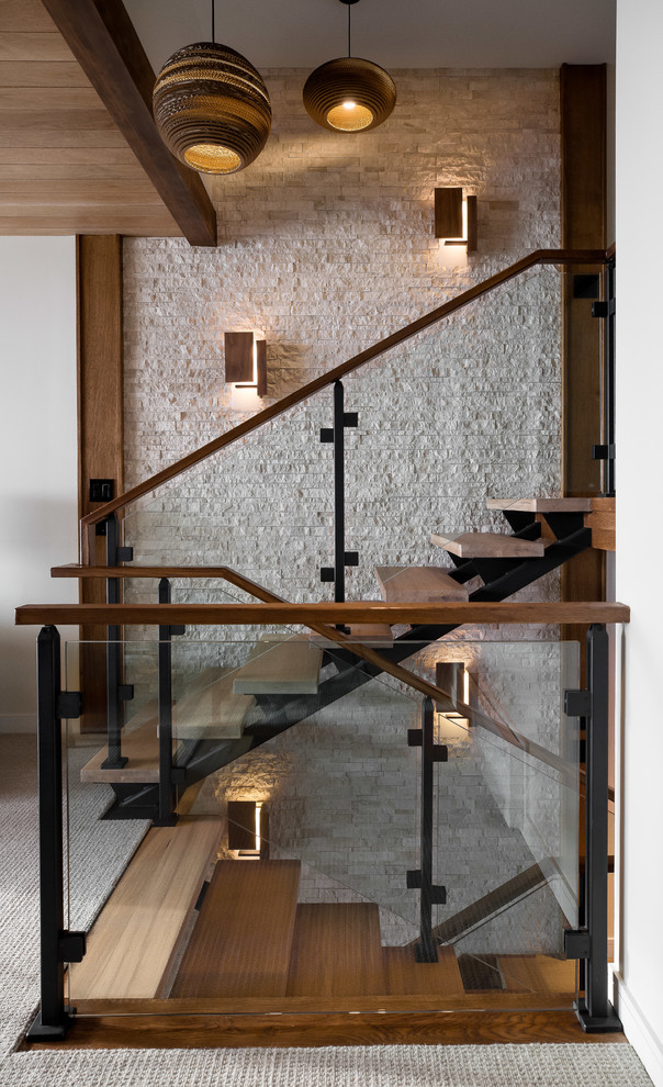 Foto di una scala contemporanea con pedata in legno, nessuna alzata e parapetto in vetro