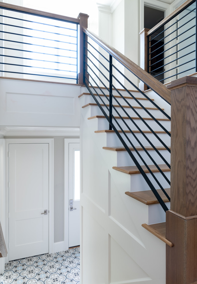 Свежая идея для дизайна: угловая деревянная лестница в стиле неоклассика (современная классика) с деревянными ступенями, металлическими перилами и панелями на стенах - отличное фото интерьера