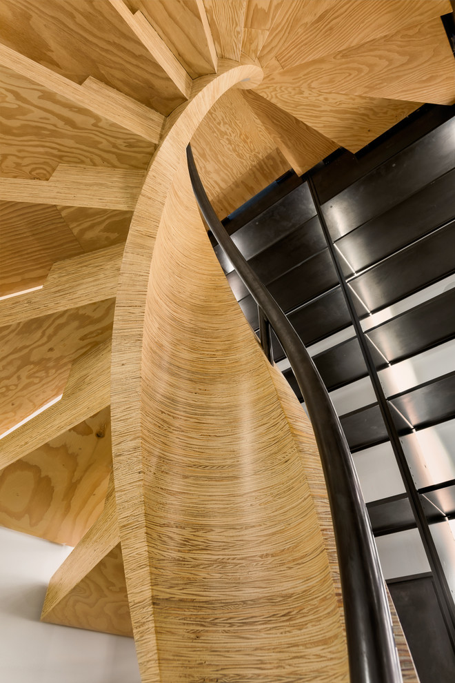 Idee per una grande scala a chiocciola moderna con pedata in legno, alzata in legno e parapetto in metallo