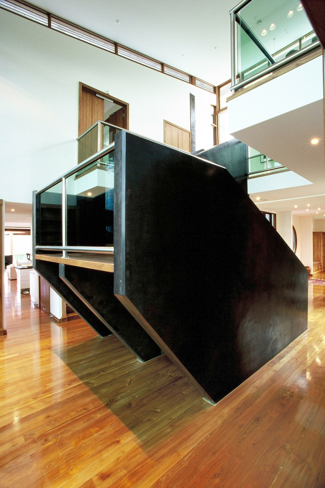Свежая идея для дизайна: огромная п-образная лестница в стиле модернизм с деревянными ступенями и металлическими перилами без подступенок - отличное фото интерьера