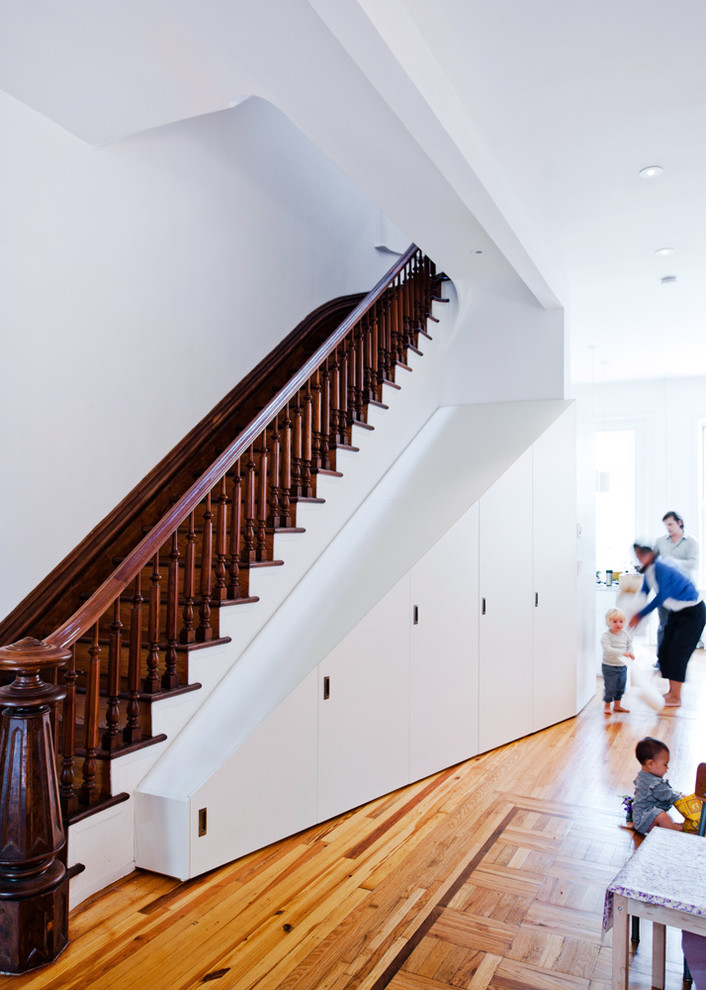 Inspiration for a traditional wood straight wood railing staircase in New York with wood risers and under stair storage.