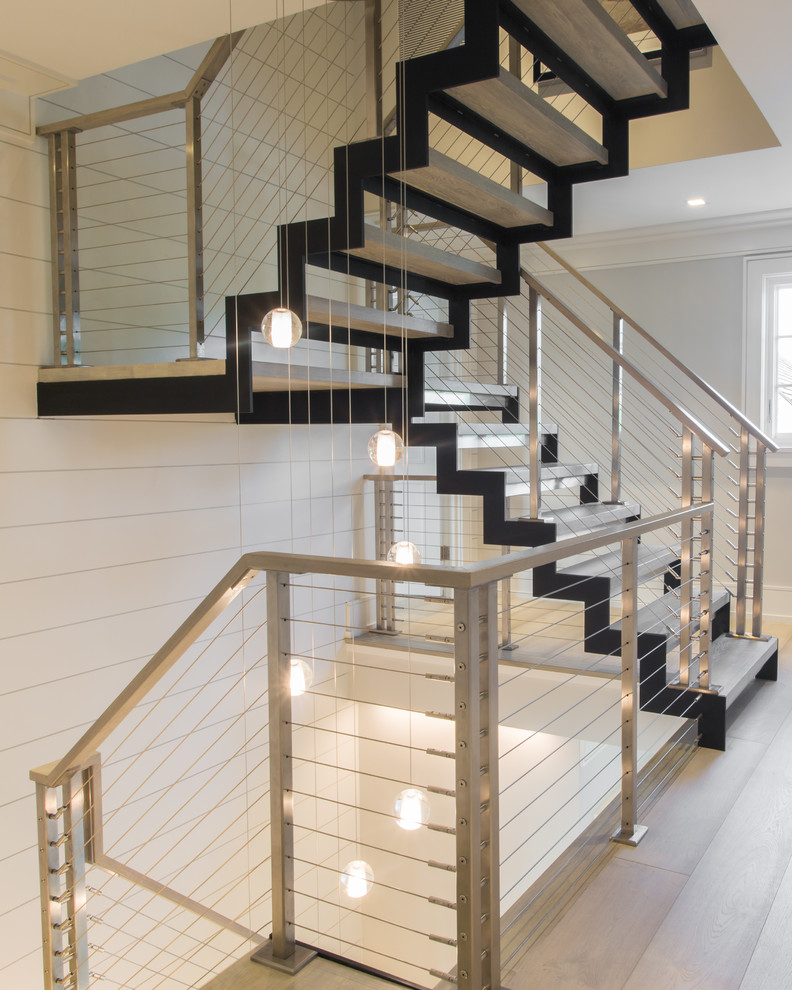 Стильный дизайн: большая металлическая лестница на больцах в стиле модернизм с деревянными ступенями и металлическими перилами - последний тренд