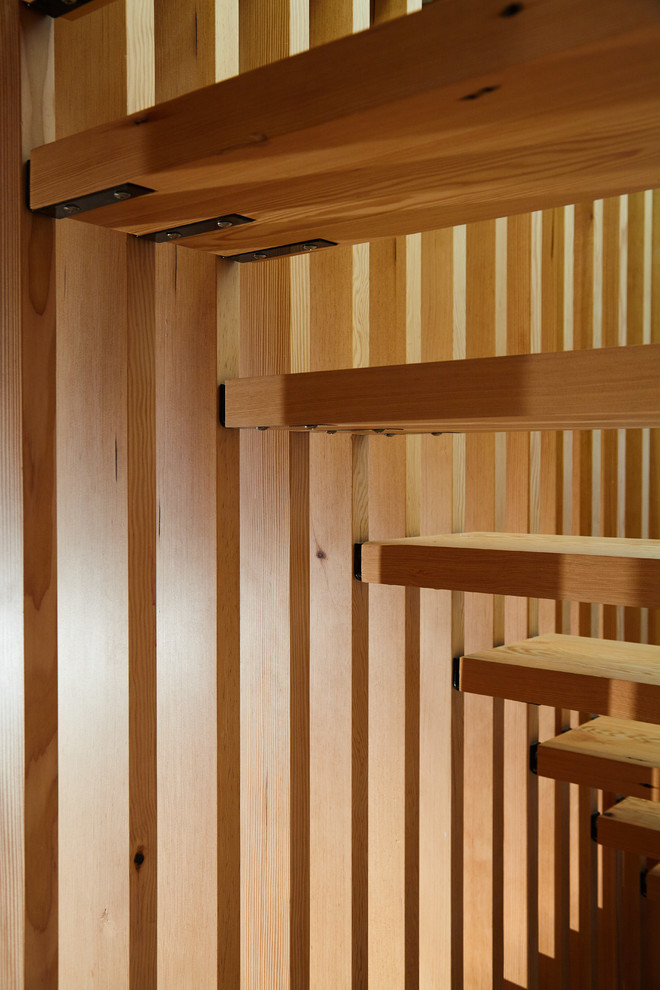 На фото: прямая лестница среднего размера в стиле модернизм с деревянными ступенями и деревянными перилами без подступенок с