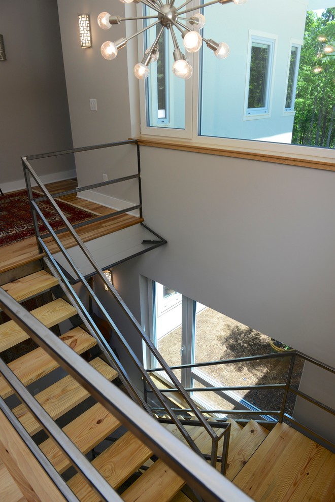 This is an example of a medium sized modern wood u-shaped staircase in Raleigh with open risers.