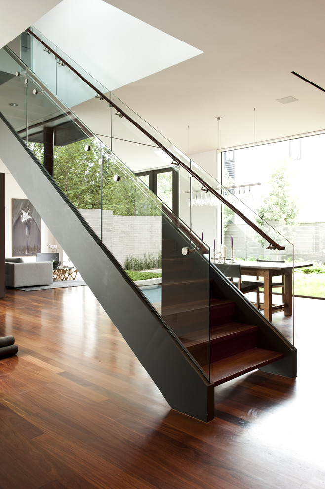Exemple d'un escalier moderne avec des marches en bois et un garde-corps en verre.