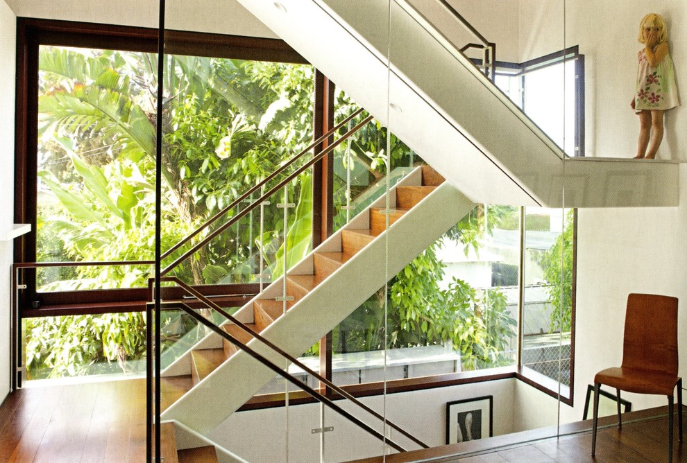 Exempel på en mellanstor modern u-trappa i trä, med sättsteg i trä och räcke i glas